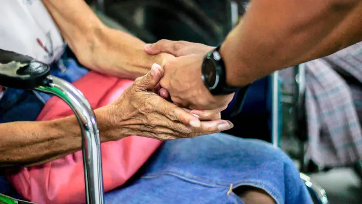 young hands holding elderly hands